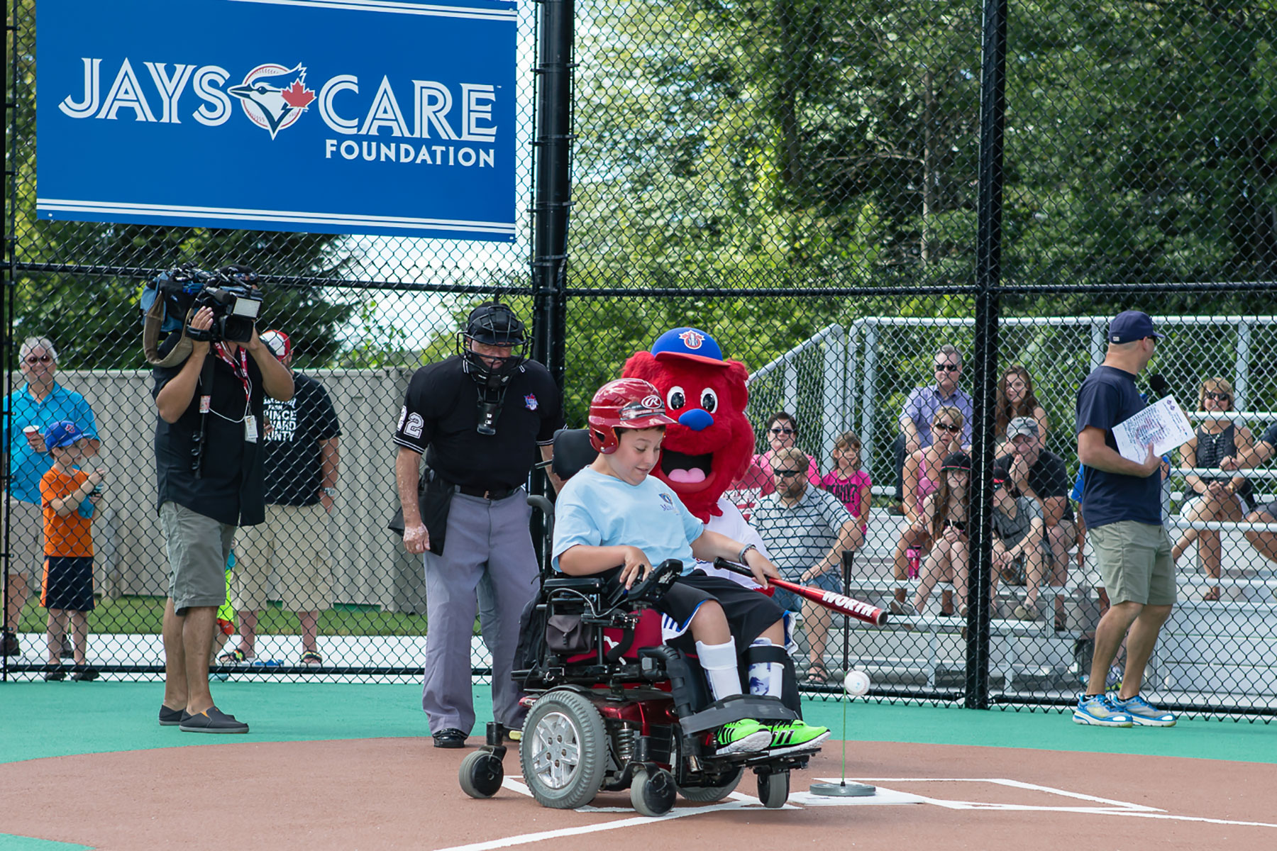 A player in a wheelchair taking advantage of the accessibly designed baseball diamond at Miracle League of Ottawa field.